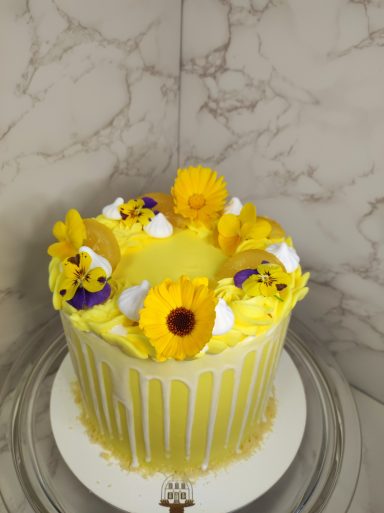 Gâteau d'anniversaire jaune avec fleurs comestibles